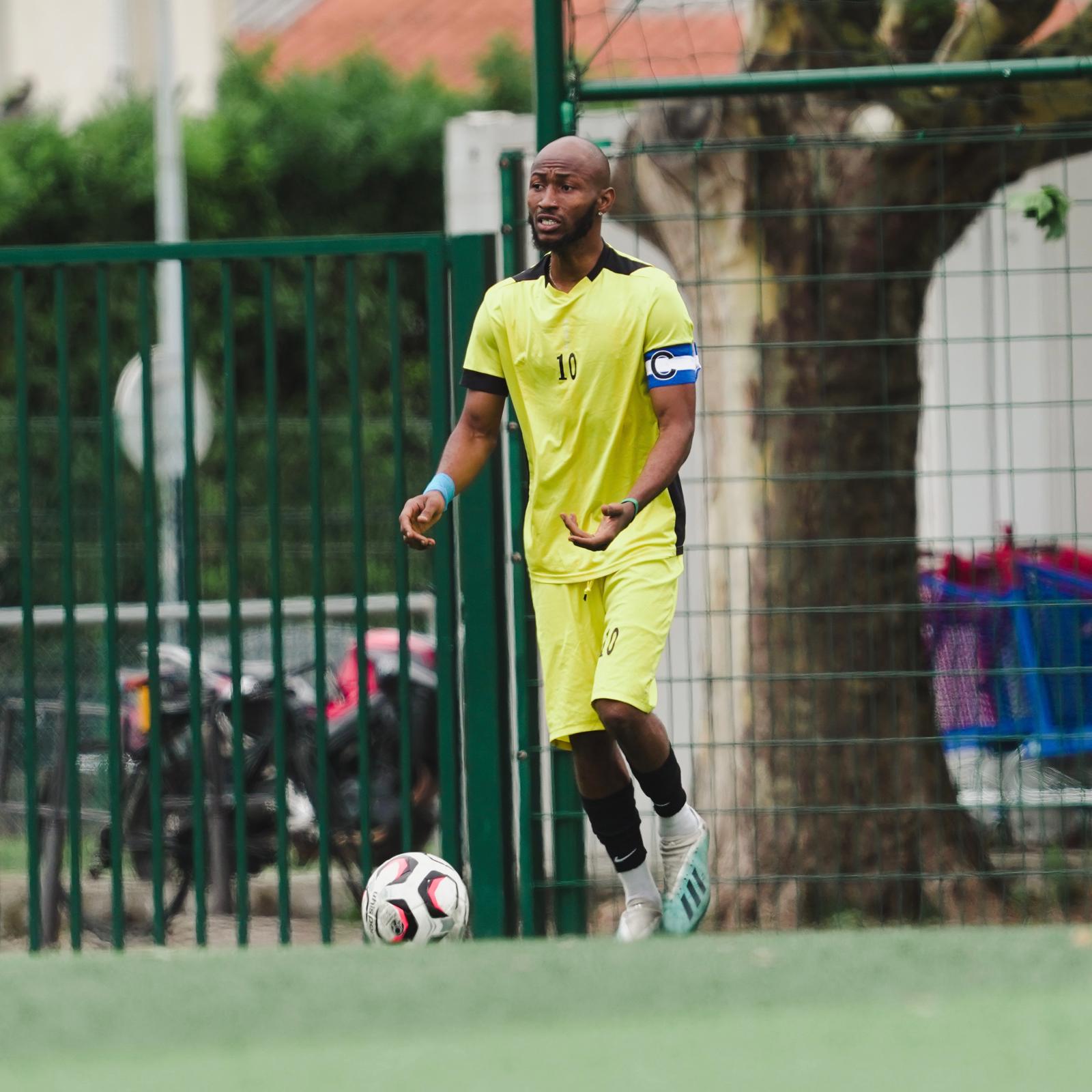 Photo d'un joueur de foot avec le ballon au pied et qui est capitaine Photo d'un joueur de foot avec le ballon au pied et qui est capitaine