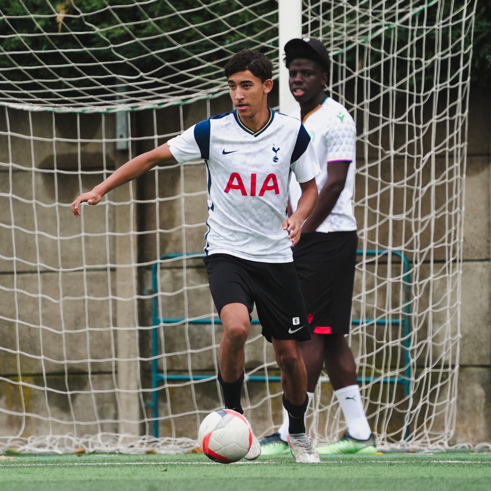 Photo d'un joueur de foot avec le ballon au pied en maillot de Tottenham Photo d'un joueur de foot avec le ballon au pied en maillot de Tottenham